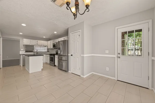 a kitchen with white cabinets and refrigerator