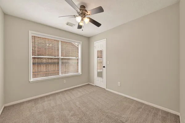 an empty room with chandelier fan
