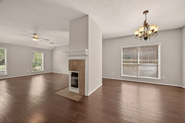a view of a livingroom with wooden floor a fireplace and window
