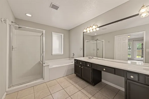 a spacious bathroom with a double vanity sink mirror and a bathtub