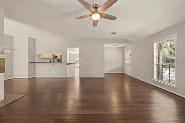 a view of a kitchen with wooden floor and a kitchen space with a sink