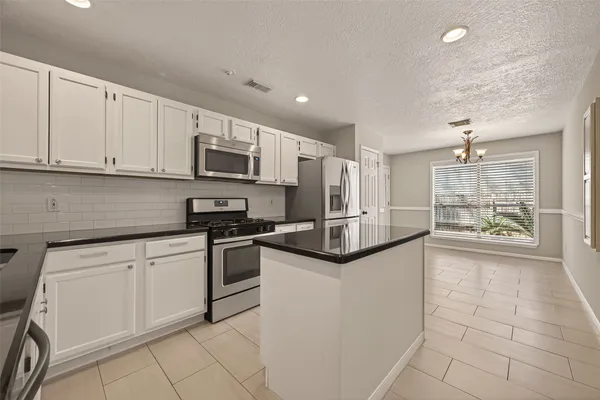 a kitchen with granite countertop a sink and white cabinets