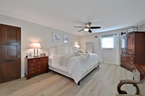 a spacious bedroom with a bed and wooden floor