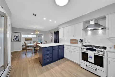 a kitchen with a stove cabinets and wooden floor