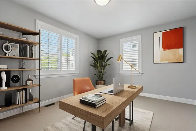 a view of a workspace with furniture and a window