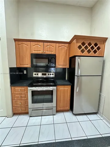 a kitchen with stainless steel appliances a refrigerator sink and microwave