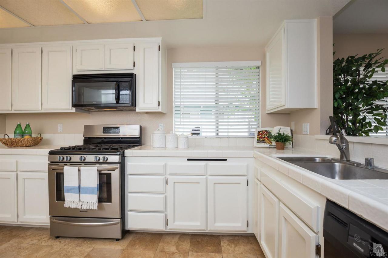 1940 Rory Lane, Unit 5 Simi Valley, CA 93063 - Photo 5 of 19 a kitchen with white cabinets and a stove