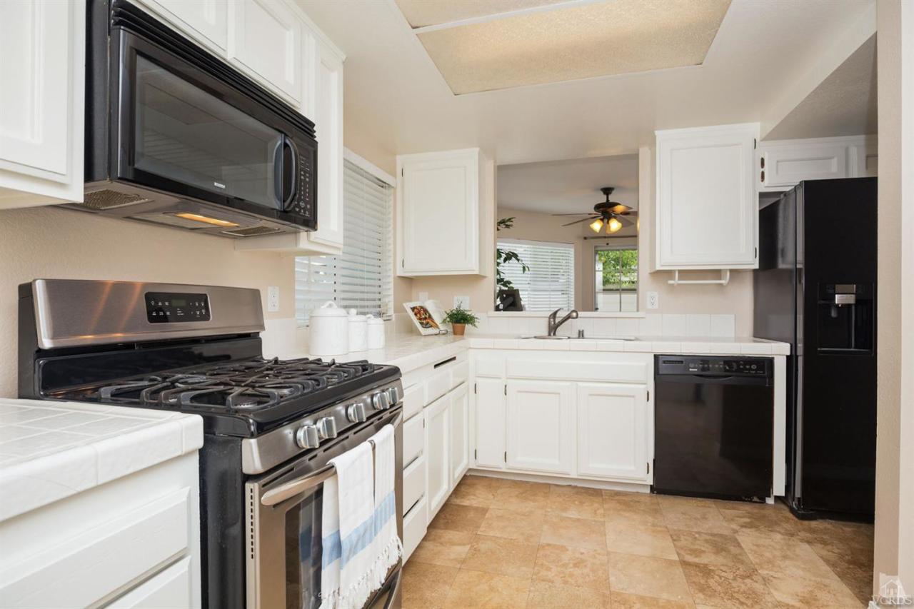 1940 Rory Lane, Unit 5 Simi Valley, CA 93063 - Photo 6 of 19 a kitchen with stainless steel appliances granite countertop a stove microwave sink and refrigerator