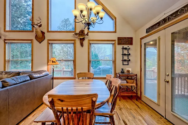 a kitchen with stainless steel appliances granite countertop a stove top oven a sink a dining table and chairs