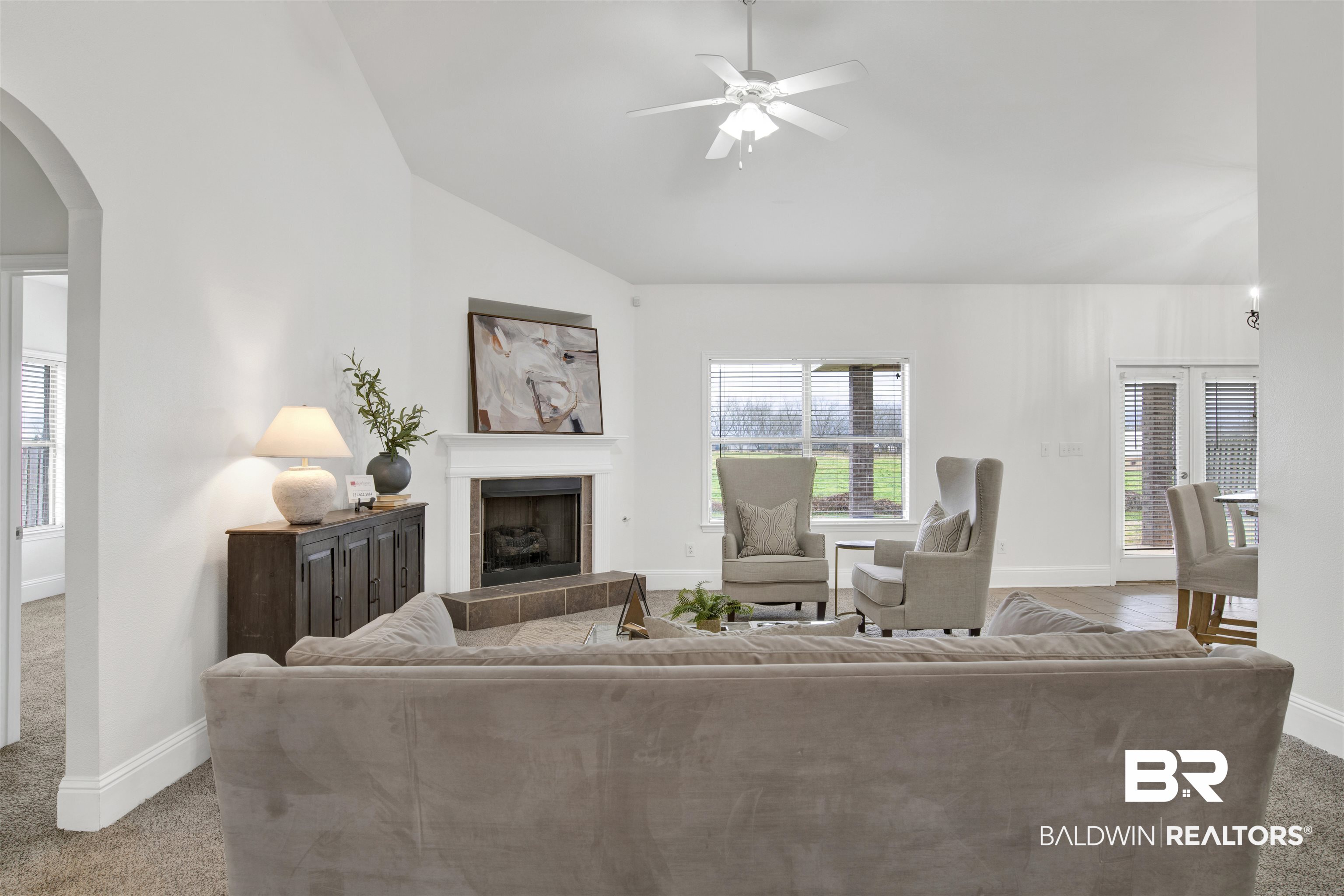 25350 Spindle Lane Daphne, AL 36526 - Photo 7 of 32 Carpeted living room with ceiling fan, a tiled fireplace, and high vaulted ceiling
