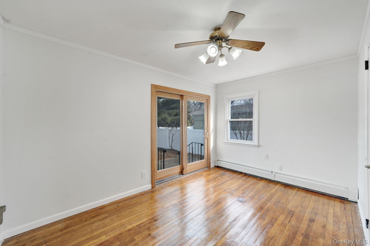 450 Rhodes Lane West Hempstead, NY 11552 - Photo 5 of 16 Bedroom with hardwood flooring and sliding glass doors and window.