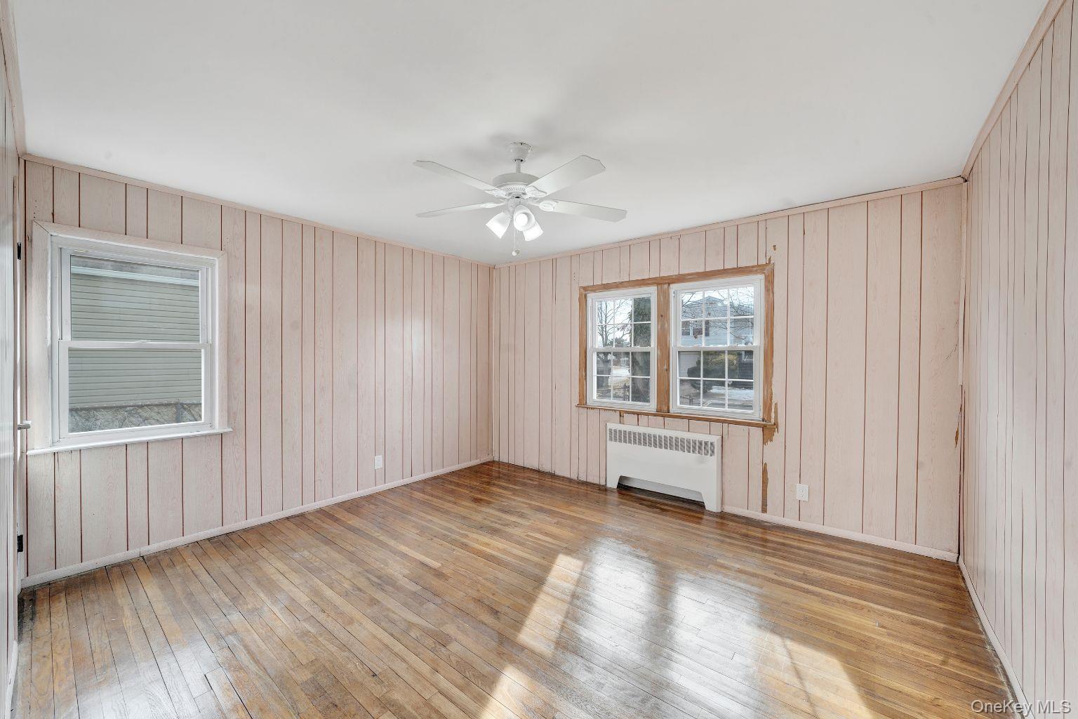 450 Rhodes Lane West Hempstead, NY 11552 - Photo 6 of 16 Bedroom with hardwood flooring and multiple windows.