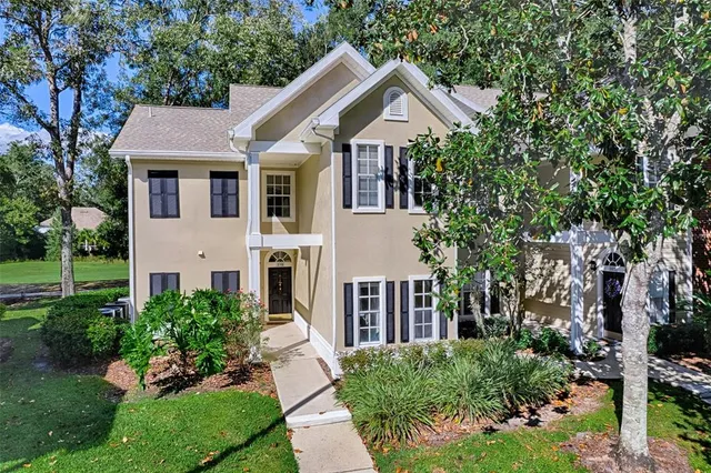 a front view of a house with a yard and trees