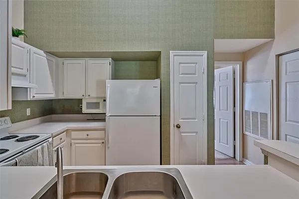 a kitchen with a refrigerator a stove a sink and a cabinets