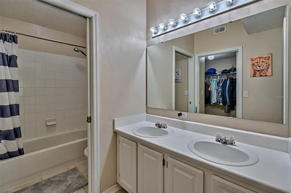a bathroom with a sink double vanity granite tub and a mirror