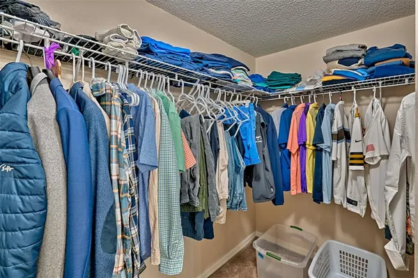 a view of walk in closet with clothes