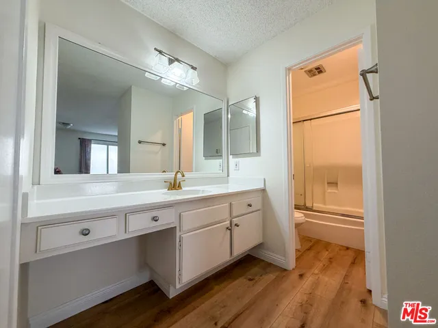 a spacious bathroom with a granite countertop sink and a mirror
