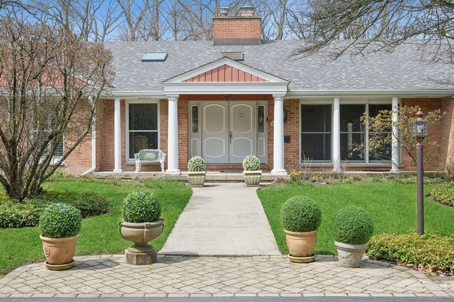 48 Meadowview Road Northfield, IL 60093 - Photo 1 of 42 a front view of a house with a garden and plants