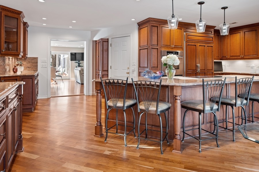 48 Meadowview Road Northfield, IL 60093 - Photo 20 of 42 a kitchen with stainless steel appliances granite countertop a stove top oven a sink a dining table and chairs with wooden floor