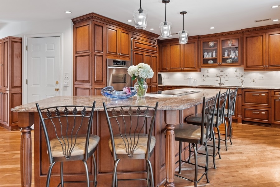 48 Meadowview Road Northfield, IL 60093 - Photo 21 of 42 a kitchen with stainless steel appliances granite countertop a stove top oven a sink a dining table and chairs