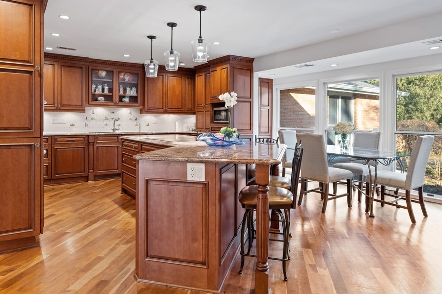 48 Meadowview Road Northfield, IL 60093 - Photo 23 of 42 a kitchen with stainless steel appliances granite countertop wooden floors stove and white cabinets