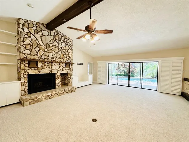 a view of an empty room with a fireplace and a window