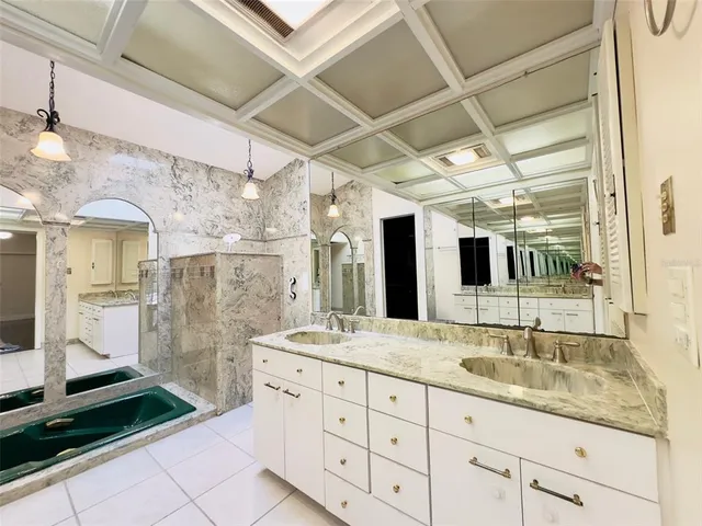 a bathroom with a sink shower and a mirror
