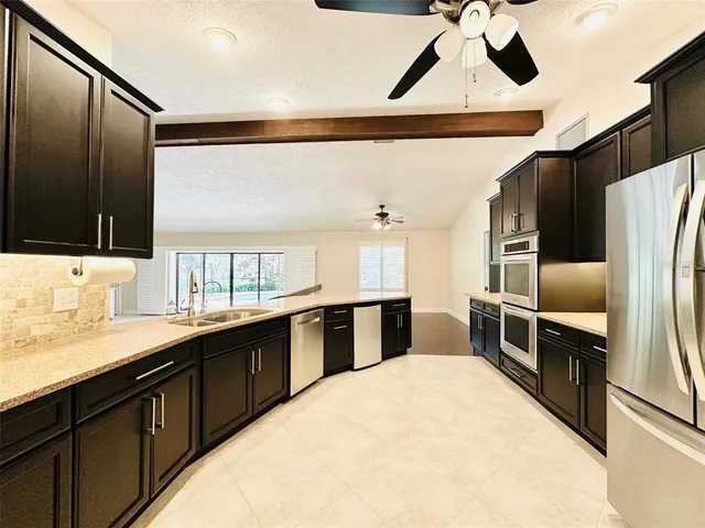 a kitchen with stainless steel appliances a sink and a refrigerator