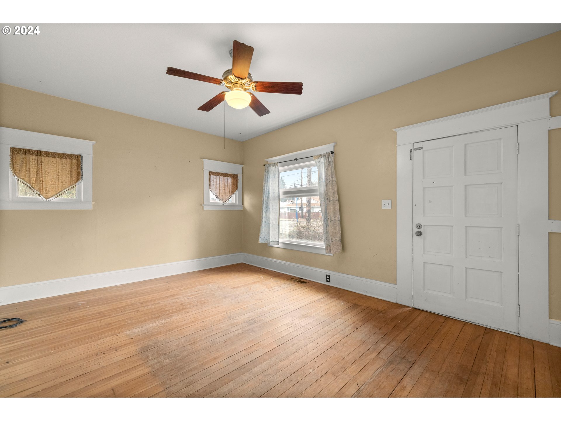 13049 Southeast Foster Road Portland, OR 97236 - Photo 3 of 19 a view of an empty room with wooden floor and a window