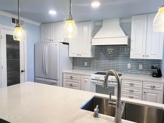 a kitchen with granite countertop a sink stainless steel appliances and cabinets
