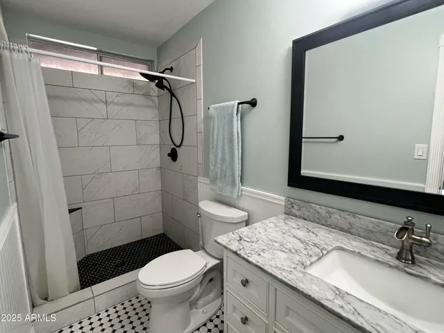 a bathroom with a granite countertop sink toilet and shower