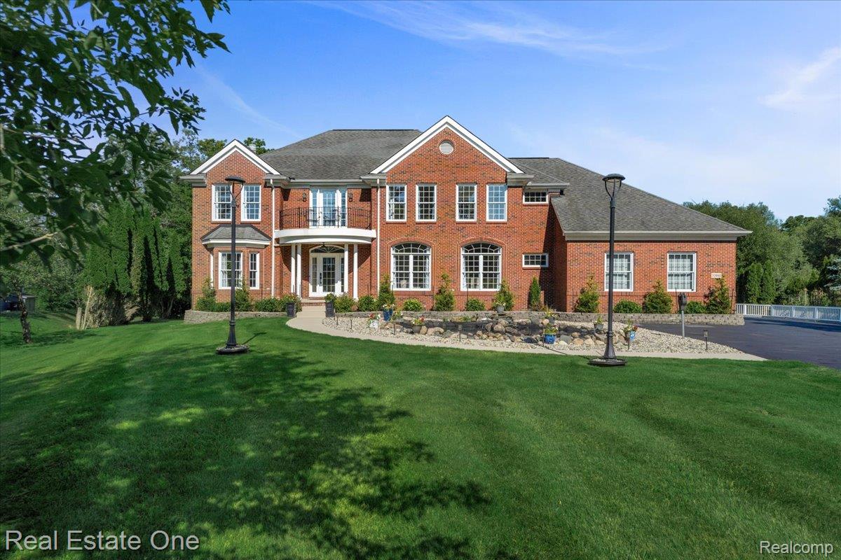 33850 Braebury Ridge Farmington, MI 48331 - Photo 3 of 85 Brick exterior featuring white-framed windows and a central entry with a rounded balcony