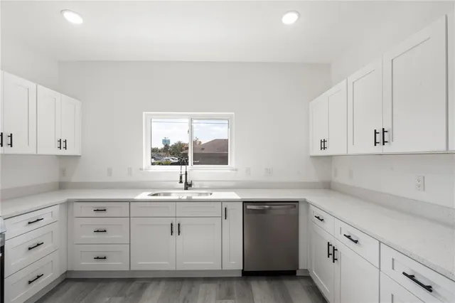 a kitchen with cabinets appliances a sink and a window