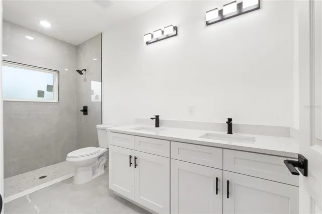 a bathroom with a sink a toilet and a mirror