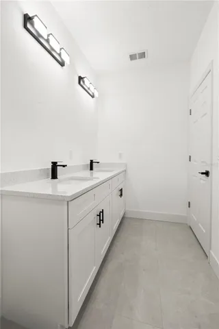 a bathroom with a double vanity sink and mirror