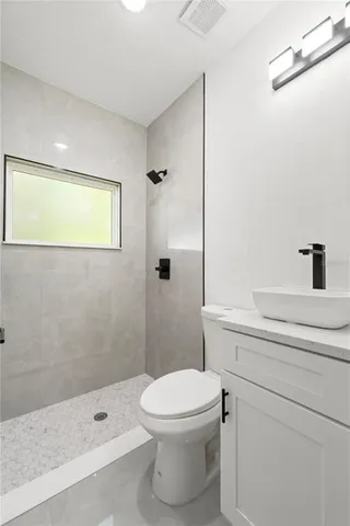a bathroom with a toilet a sink and shower
