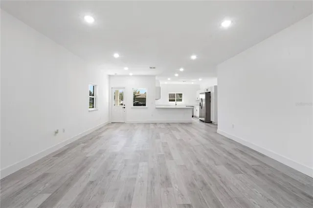 a view of a big room with wooden floor and windows