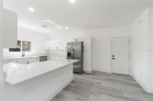 a large white kitchen with a large window