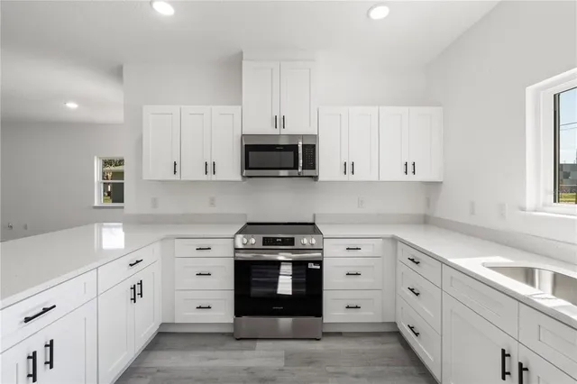 a kitchen with white cabinets and stainless steel appliances