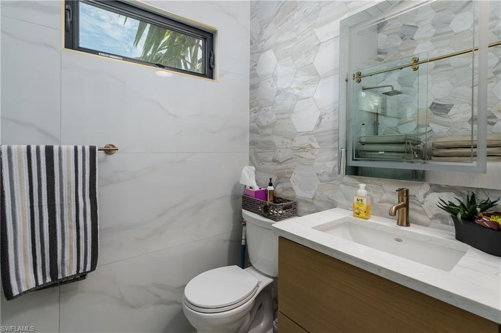 13613 Snapper Lane Naples, FL 34114 - Photo 16 of 49 a bathroom with a sink a toilet and shower