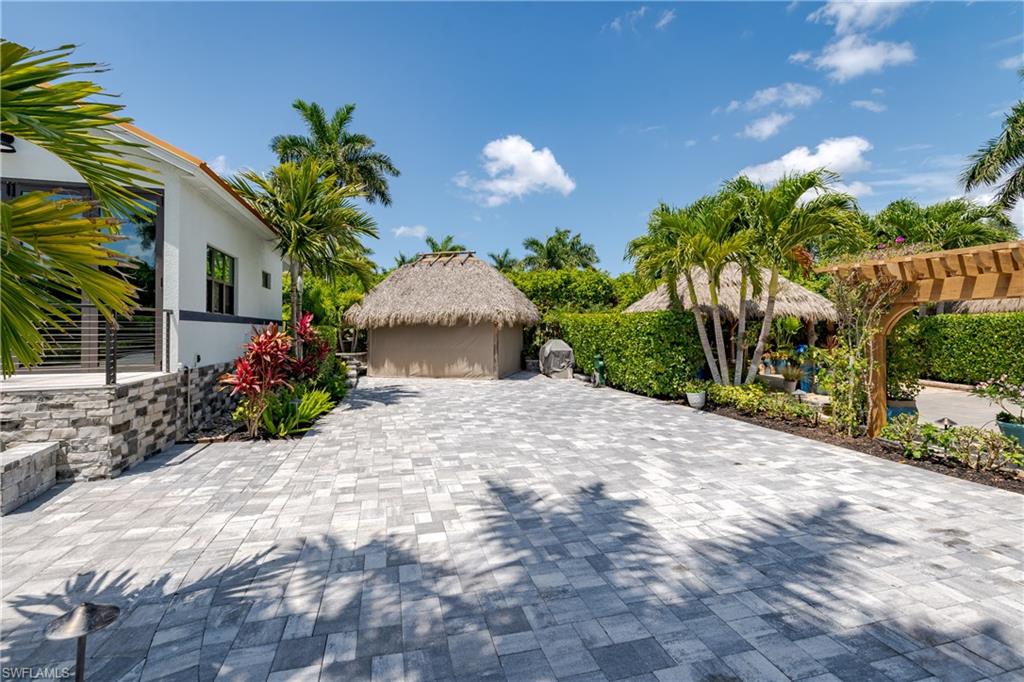 13613 Snapper Lane Naples, FL 34114 - Photo 24 of 49 a front view of a house with a yard and potted plants
