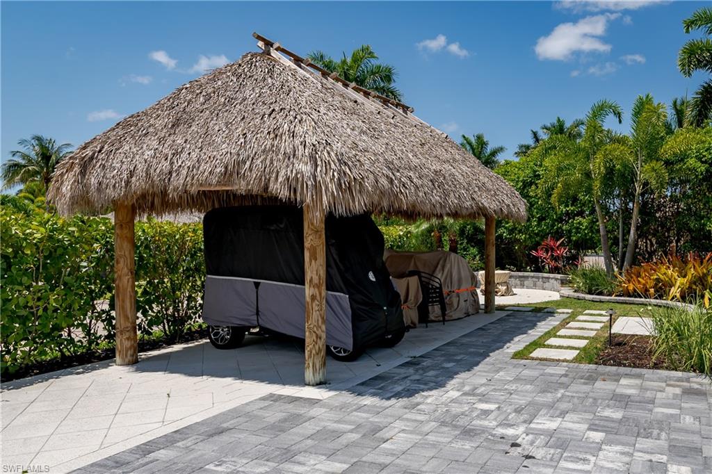13613 Snapper Lane Naples, FL 34114 - Photo 32 of 49 a view of a patio with table and chairs under an umbrella