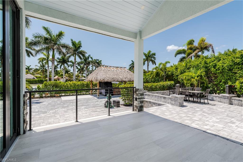 13613 Snapper Lane Naples, FL 34114 - Photo 7 of 49 a view of a patio with a table and chairs under an umbrella