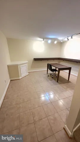 a view of an empty room with furniture and a window