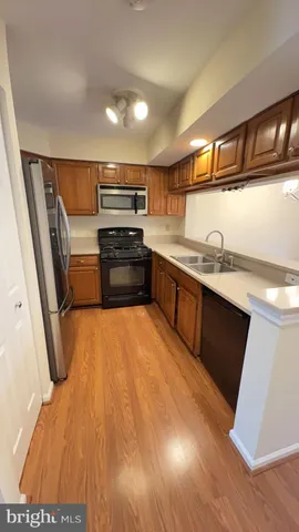 a kitchen with stainless steel appliances a refrigerator and wooden floor