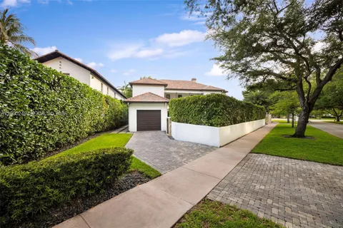 a front view of a house with a yard and trees