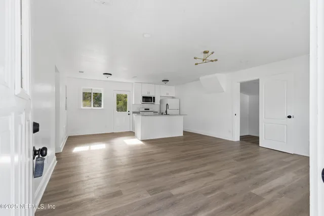 a view of empty room with wooden floor and window