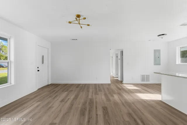 a view of an empty room with wooden floor
