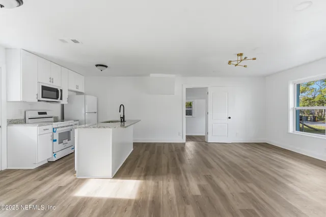 a bathroom with a granite countertop bathtub shower sink vanity and toilet