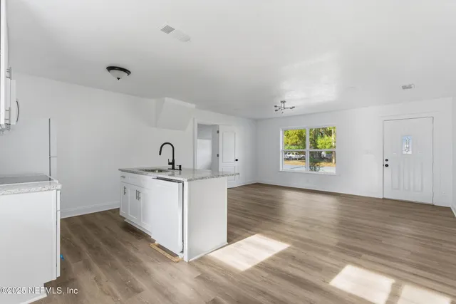 a view of a kitchen with wooden floor and electronic appliances
